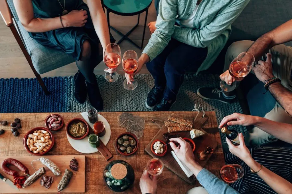 top view of table diner with tapas food - friends people eating and grabbing appetizer sitting around together