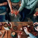 top view of table diner with tapas food - friends people eating and grabbing appetizer sitting around together