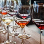 Three wine glasses with samples on wood counter